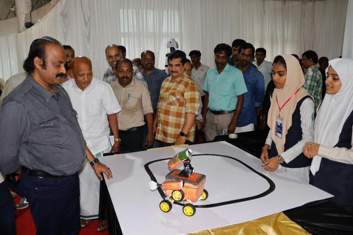 Educators watching a student line-follower robot demo